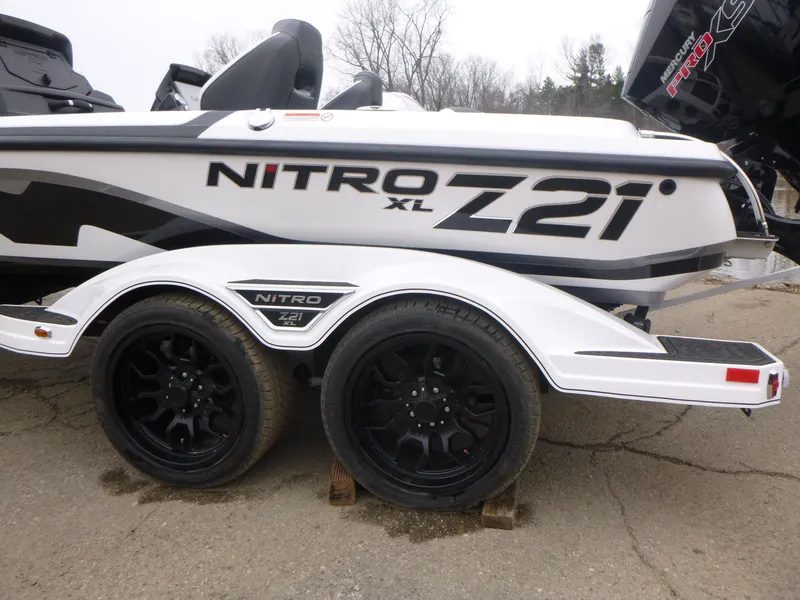 Slide: The Image of 2025 Nitro Z21 XL Pro boat on trailer with black wheels, side view. - 1