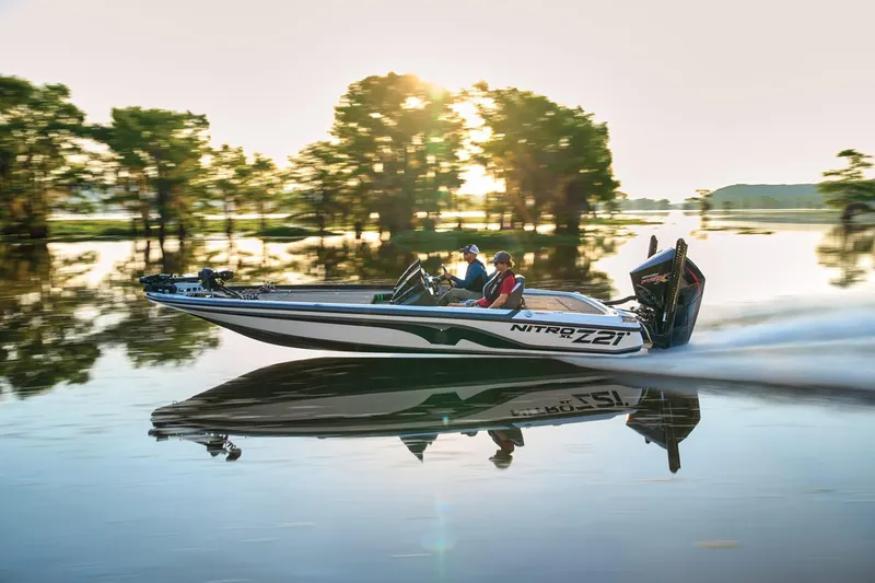 Slide: The Image of 2025 Nitro Z21 XL Pro boat speeding on a serene lake at sunset. - 42