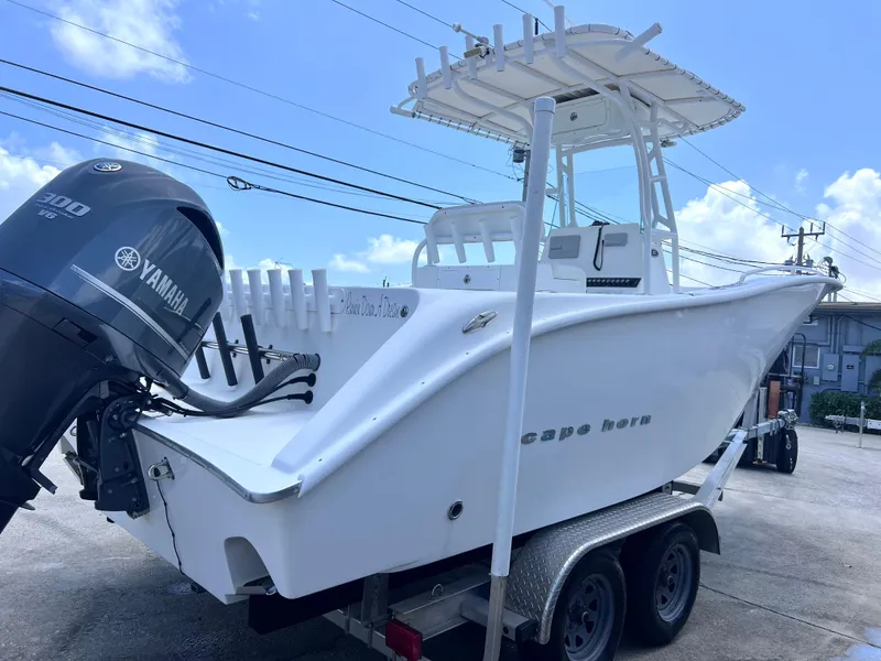 Slide: The Image of 2017 Cape Horn 22 OS boat on trailer with Yamaha engine, under clear blue sky. - 3