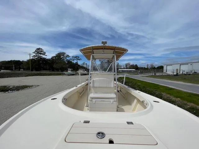Slide: The Image of 2013 Parker 21 SE boat with center console and canopy, parked on gravel near road. - 16