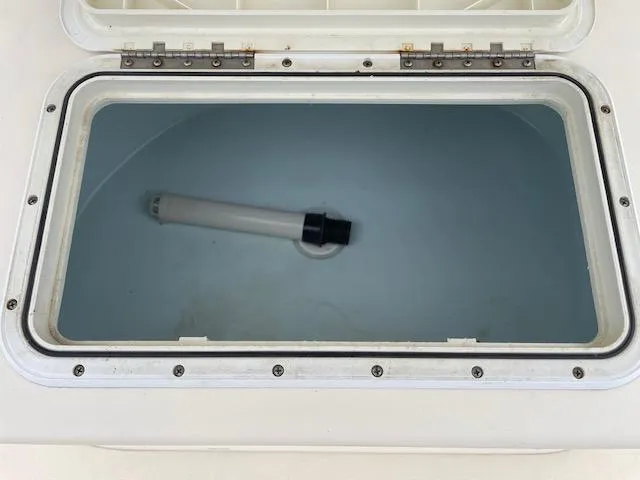 Slide: The Image of Open storage compartment on Parker 21 SE boat, 2013 model, with a cylindrical object inside. - 18