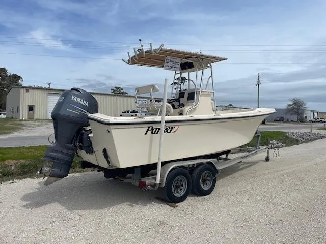 Slide: The Image of 2013 Parker 21 SE boat on trailer with Yamaha outboard motor, parked outdoors. - 2