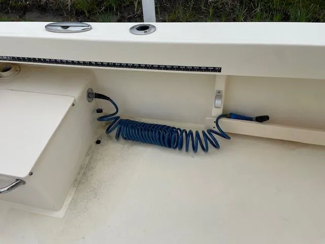 Slide: The Image of 2013 Parker 21 SE boat interior with coiled blue hose and measuring tape. - 20