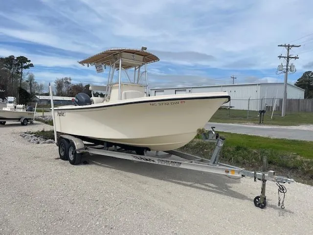 Slide: The Image of 2013 Parker 21 SE boat on trailer, parked outdoors under cloudy sky. - 3