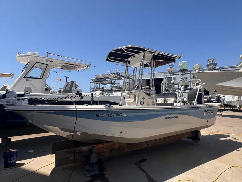 Slide: The Image of 2024 Carolina Skiff 21 LS boat displayed at a marina under clear blue skies. - 0