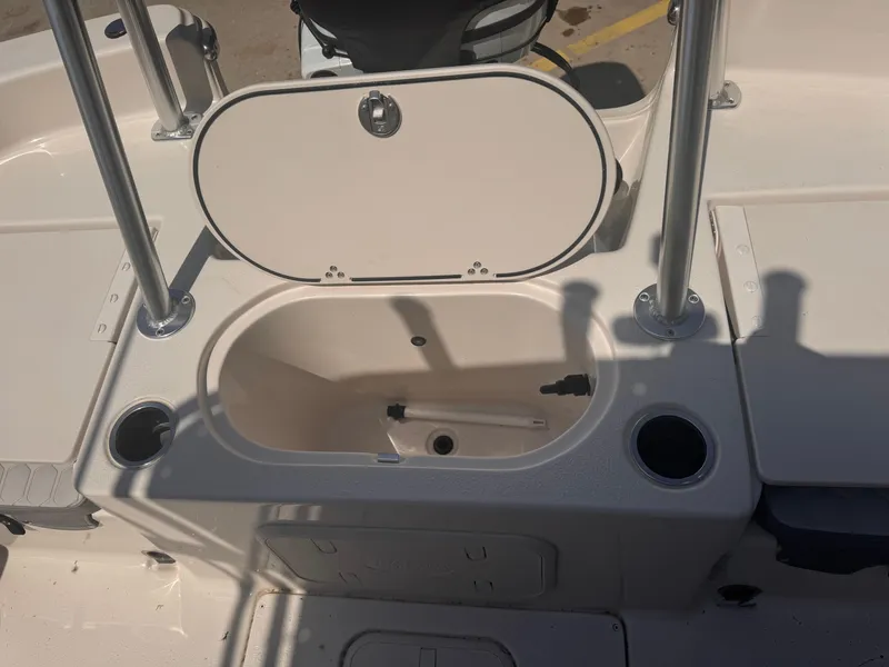 Slide: The Image of 2024 Carolina Skiff 21 LS boat interior with open storage compartment and cup holders. - 15