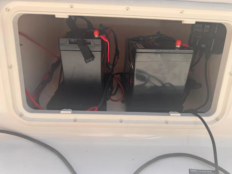 Slide: The Image of 2024 Carolina Skiff 21 LS boat battery compartment with dual batteries and wiring. - 5