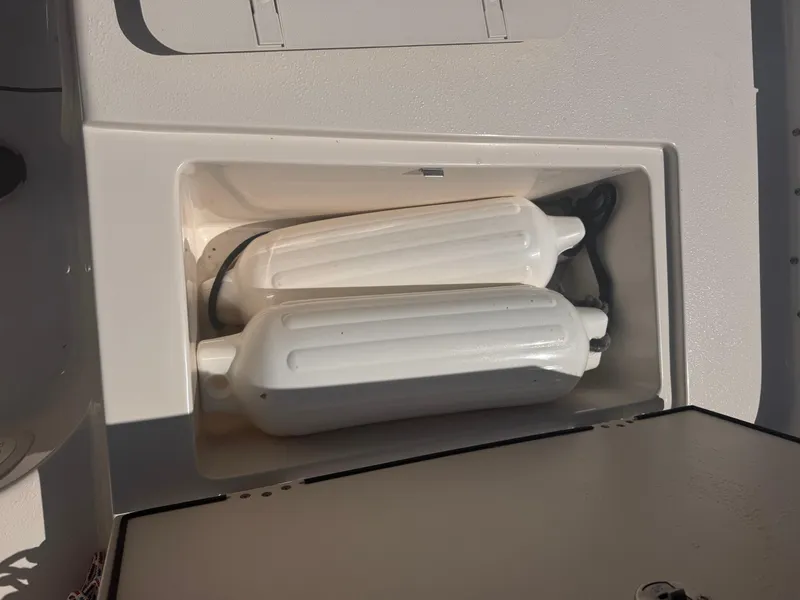 Slide: The Image of Storage compartment with boat fenders on a 2024 Carolina Skiff 21 LS. - 8