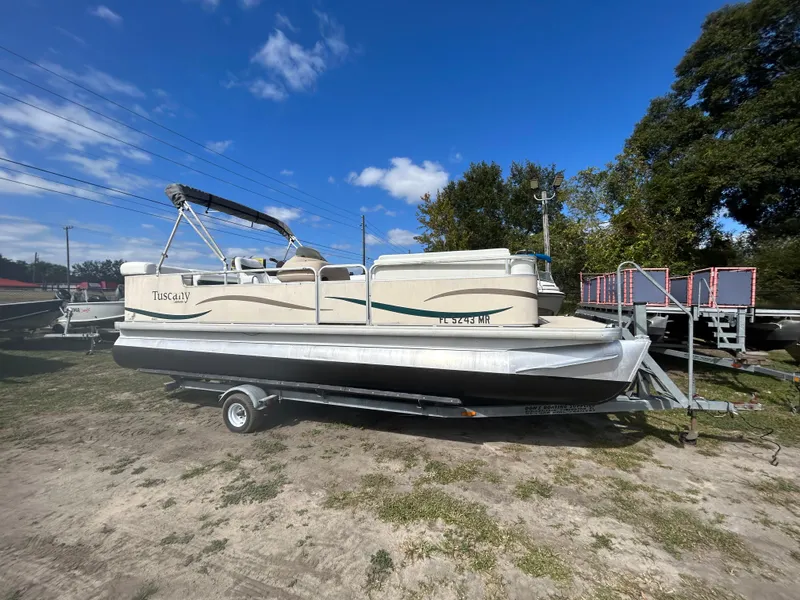 The Image of 2004 Godfrey Tuscany 220 pontoon boat on trailer under blue sky. - 1