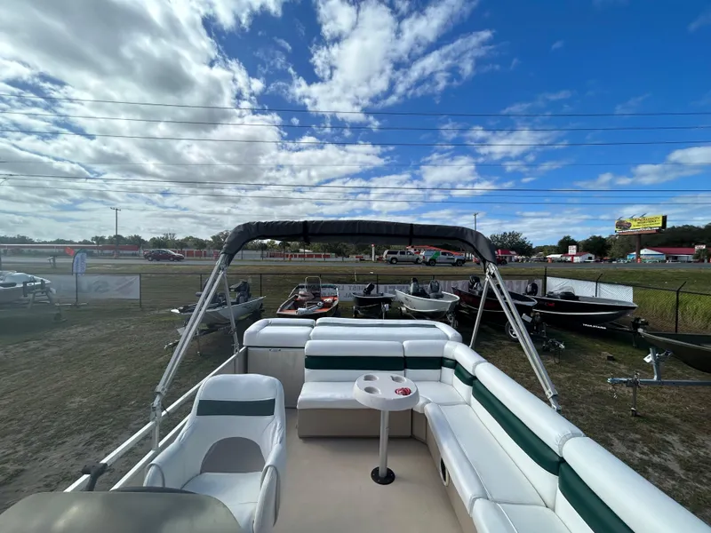 Slide: The Image of 2004 Godfrey Tuscany 220 pontoon boat with seating, under a partly cloudy sky. - 12
