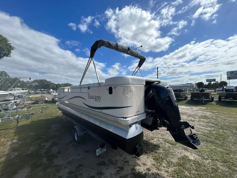Slide: The Image of 2004 Godfrey Tuscany 220 pontoon boat on grassy lot under blue sky. - 14