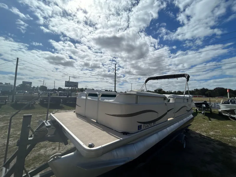 Slide: The Image of 2004 Godfrey Tuscany 220 pontoon boat under a cloudy sky in a parking lot. - 3