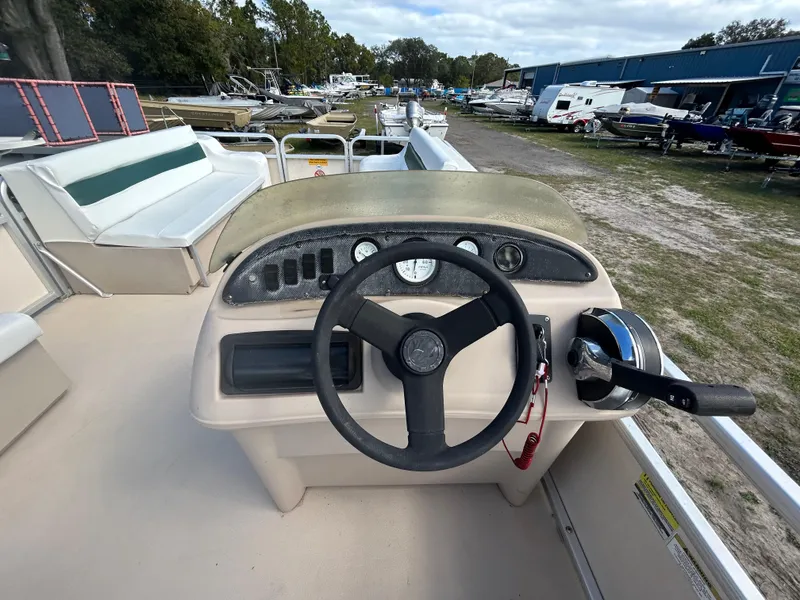 Slide: The Image of Steering console of a 2004 Godfrey Tuscany 220 pontoon boat in a marina. - 8