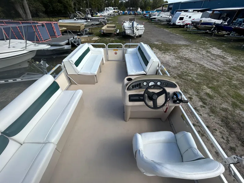 Slide: The Image of 2004 Godfrey Tuscany 220 pontoon boat with spacious seating and steering console, docked outdoors. - 9