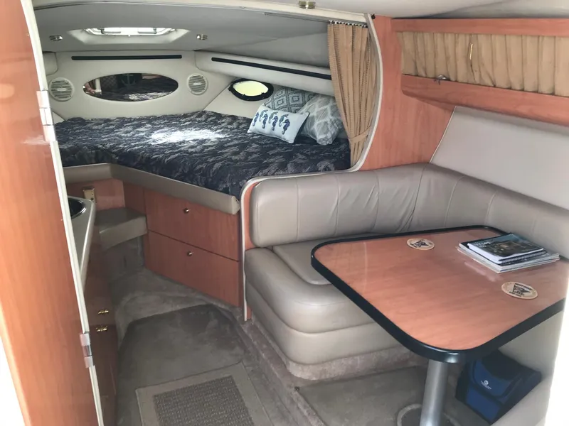 Slide: The Image of 1999 Regal 292 Commodore cabin interior with bed, seating area, and table. - 10