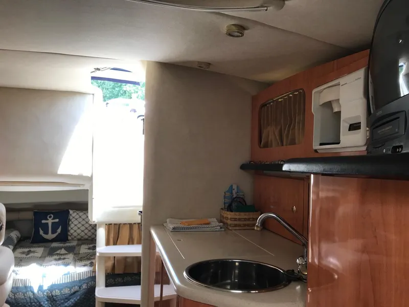 Slide: The Image of Interior of 1999 Regal 292 Commodore boat with kitchenette and cozy sleeping area. - 14