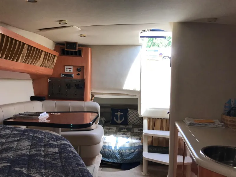 Slide: The Image of Interior of 1999 Regal 292 Commodore boat with seating, table, and nautical decor. - 15