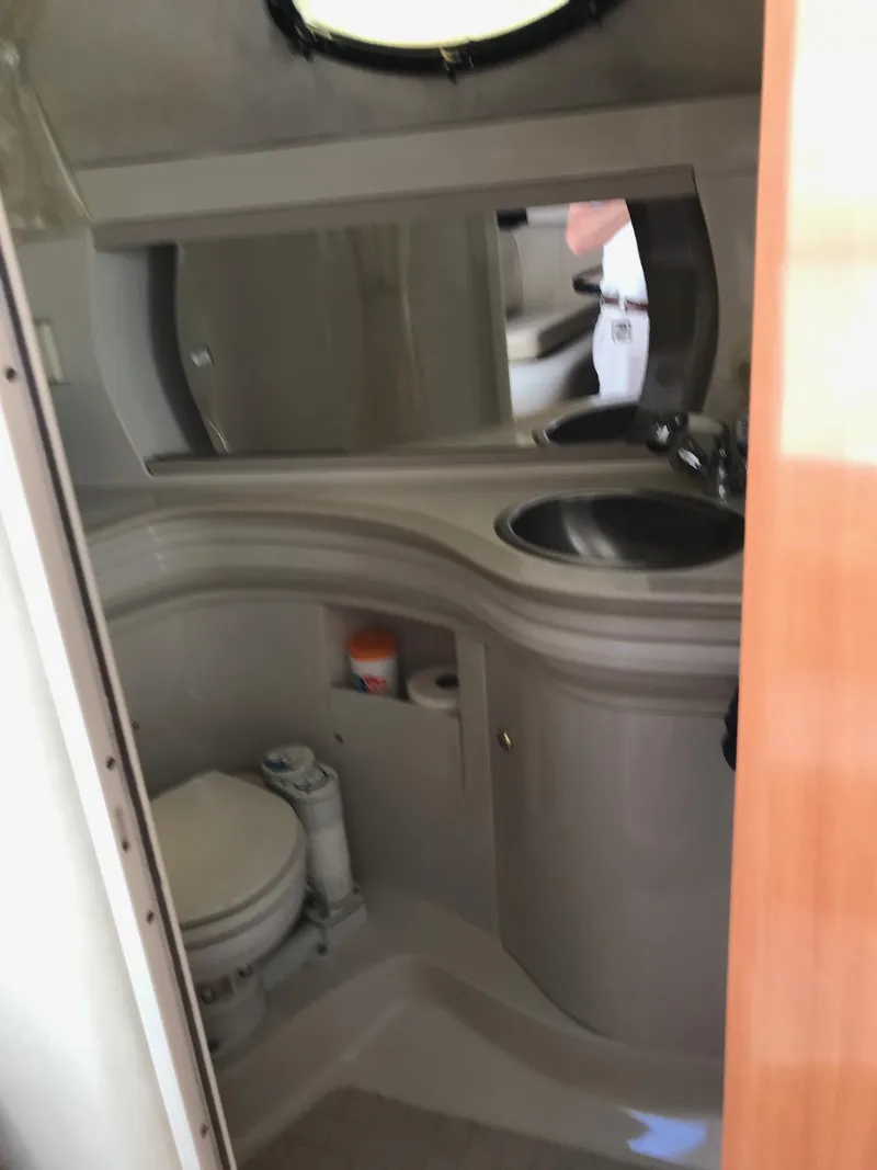 Slide: The Image of 1999 Regal 292 Commodore boat bathroom with sink, toilet, and mirror. - 16
