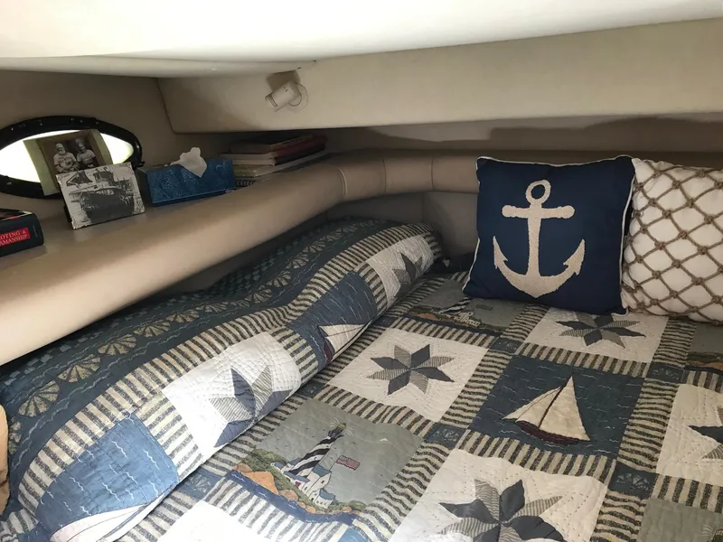 Slide: The Image of Cozy cabin interior of 1999 Regal 292 Commodore with nautical-themed bedding and decor. - 18