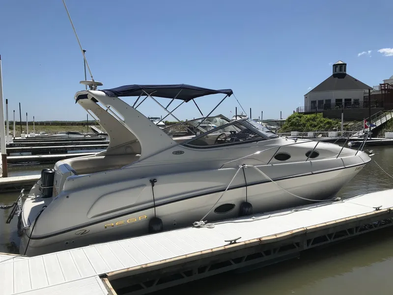 Slide: The Image of 1999 Regal 292 Commodore boat docked at marina under clear blue sky. - 3