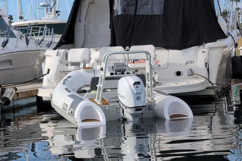 Slide: The Image of Tide Craft Nantucket 12 boat docked, 2025 model, with outboard motor, in marina setting. - 5