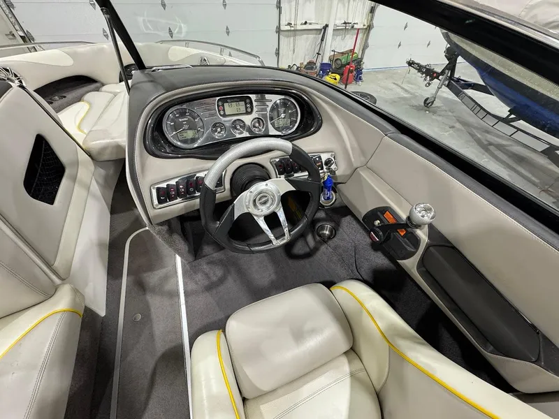 Slide: The Image of Interior of a 2007 Malibu Sunscape 23 LSV boat, featuring a sleek dashboard and steering wheel. - 12