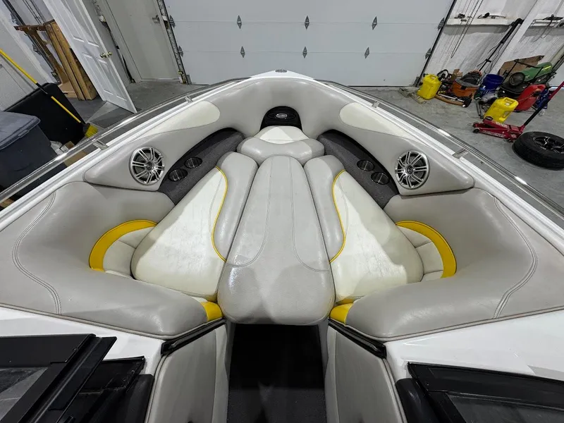 Slide: The Image of 2007 Malibu Sunscape 23 LSV boat interior with white and yellow seating, speakers, and storage compartments. - 14