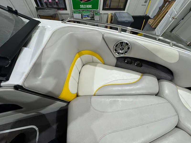 Slide: The Image of 2007 Malibu Sunscape 23 LSV boat interior with white and yellow seating, speaker, and cup holders. - 15