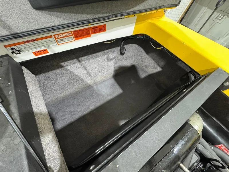 Slide: The Image of 2007 Malibu Sunscape 23 LSV storage compartment with warning labels and carpeted interior. - 19