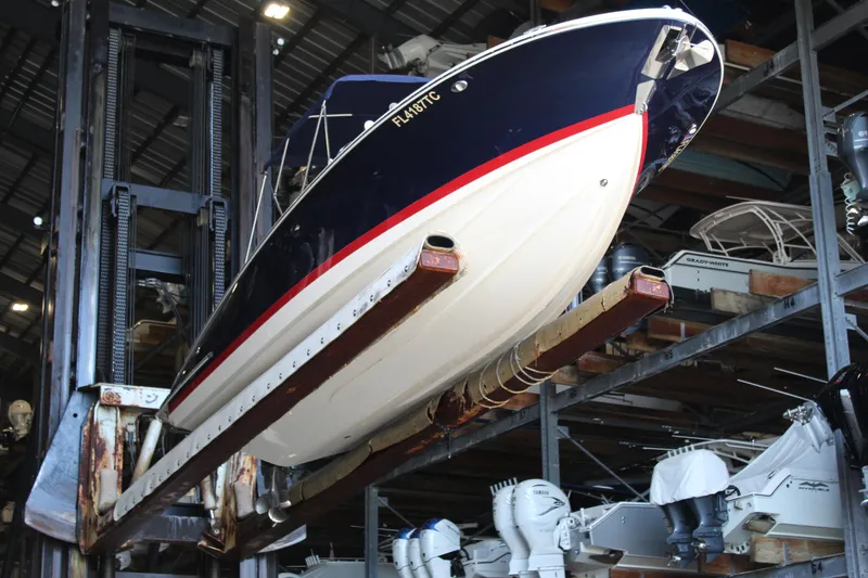 Slide: The Image of 2022 Chris-Craft Launch 27 boat stored in a marina warehouse, elevated on a rack. - 33