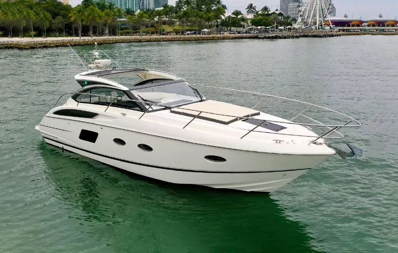 Slide: The Image of 2016 Princess V39 yacht cruising on calm waters near a scenic shoreline. - 0