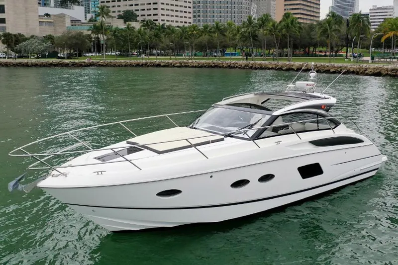 Slide: The Image of 2016 Princess V39 yacht cruising on a scenic waterway near a cityscape. - 1