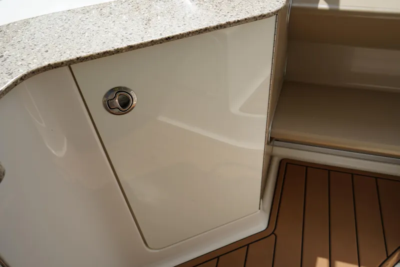 Slide: The Image of 2016 Sea Ray 330 Sundancer interior detail with sleek cabinetry and wood flooring. - 13