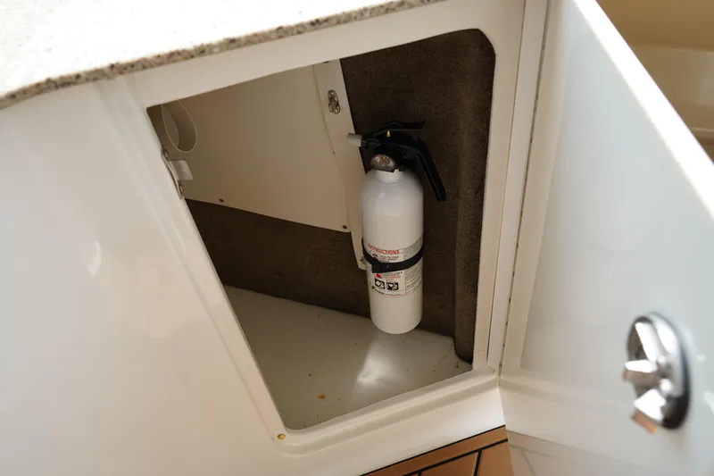 Slide: The Image of Fire extinguisher in cabinet of 2016 Sea Ray 330 Sundancer boat. - 14