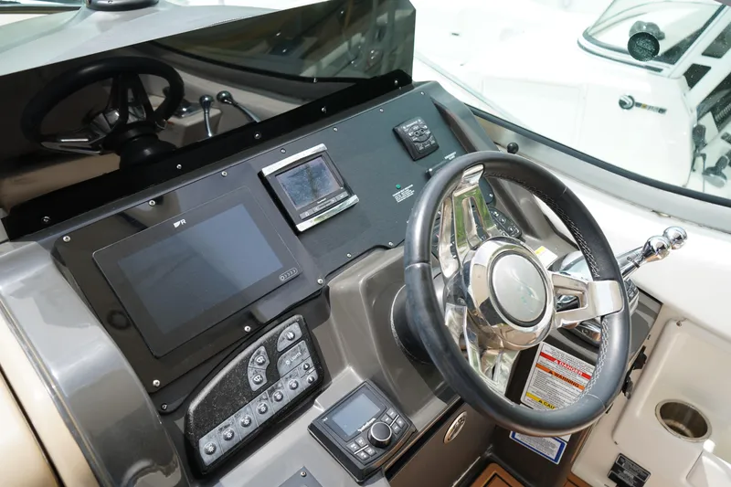 Slide: The Image of 2016 Sea Ray 330 Sundancer helm with modern navigation controls and steering wheel. - 15