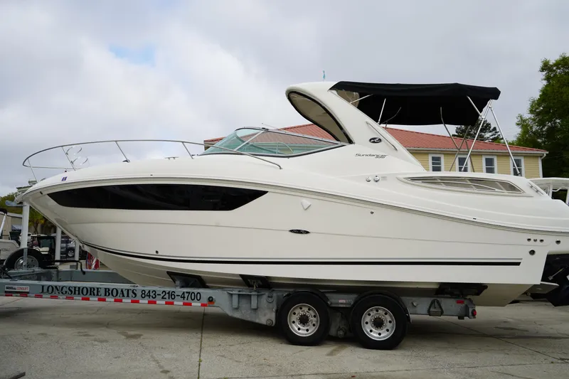 Slide: The Image of 2016 Sea Ray 330 Sundancer boat on trailer, side view, with black canopy. - 2