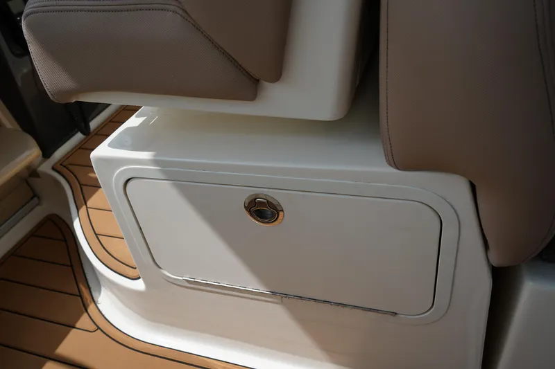 Slide: The Image of 2016 Sea Ray 330 Sundancer interior storage compartment with beige seating and wood flooring. - 26