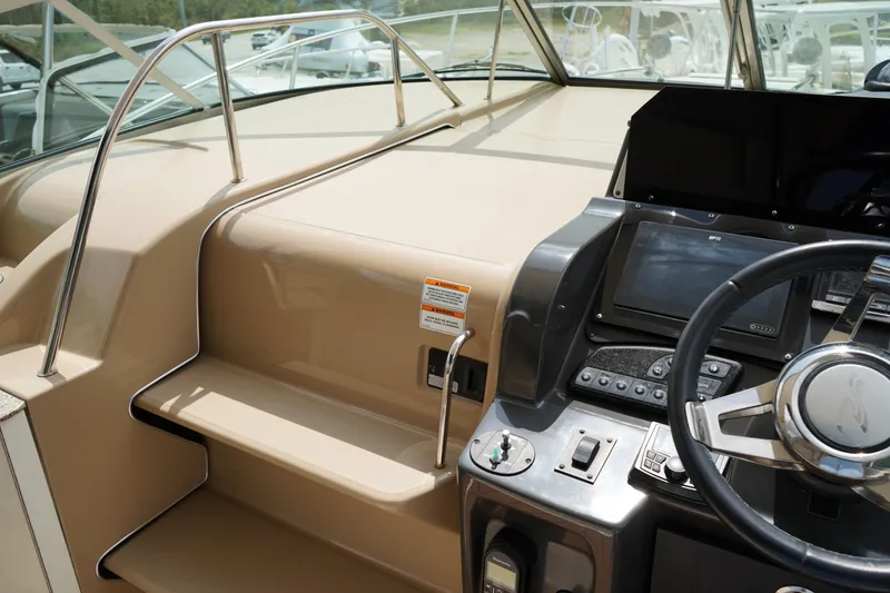 Slide: The Image of 2016 Sea Ray 330 Sundancer helm with steering wheel and navigation controls. - 30