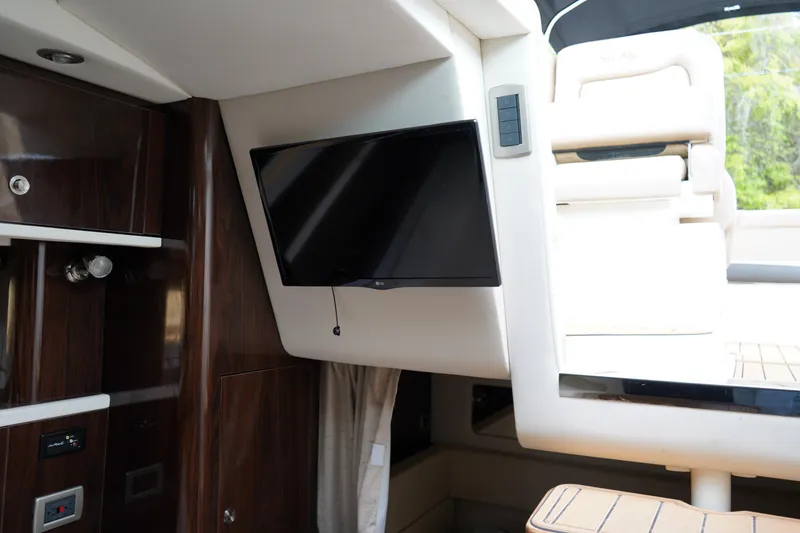 Slide: The Image of Interior of 2016 Sea Ray 330 Sundancer with mounted TV and luxurious seating. - 35