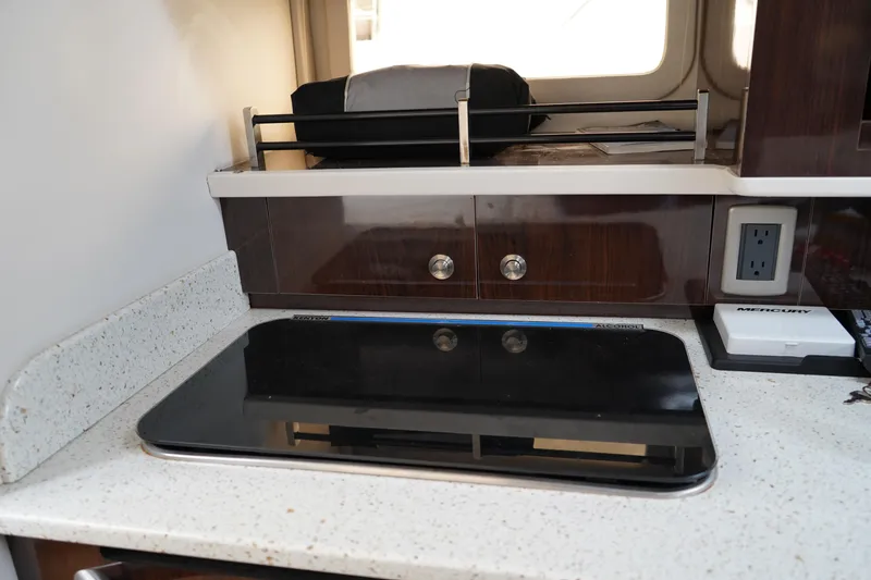 Slide: The Image of Modern kitchen area in 2016 Sea Ray 330 Sundancer yacht with sleek countertop and stove. - 38
