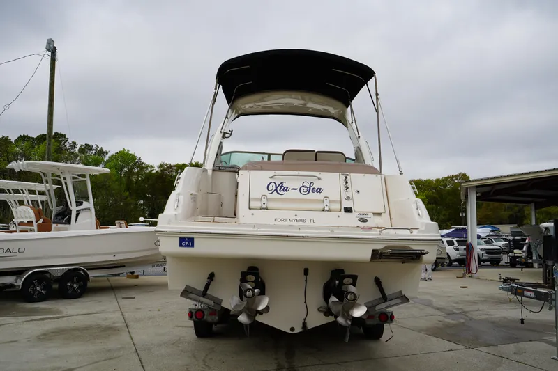 Slide: The Image of 2016 Sea Ray 330 Sundancer boat docked, rear view with dual propellers and canopy. - 4