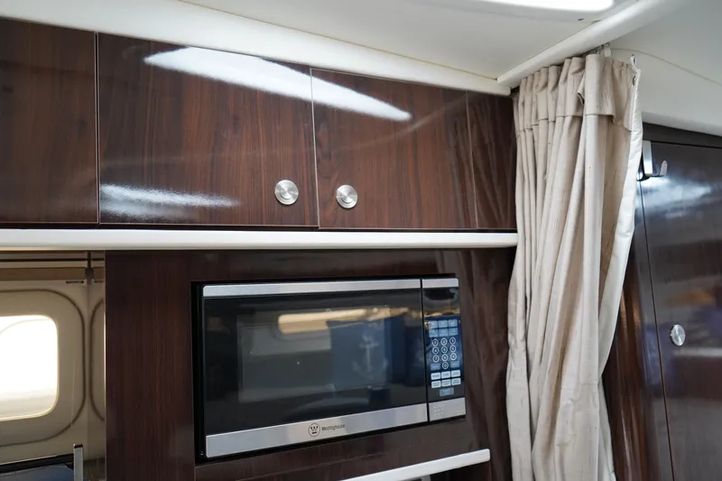 Slide: The Image of Interior of 2016 Sea Ray 330 Sundancer with microwave and wooden cabinetry. - 41