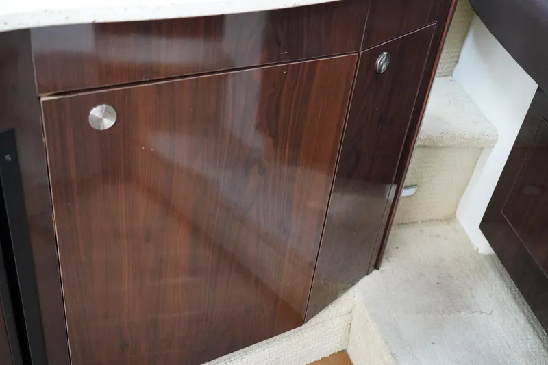 Slide: The Image of 2016 Sea Ray 330 Sundancer interior with polished wood cabinetry and carpeted steps. - 42