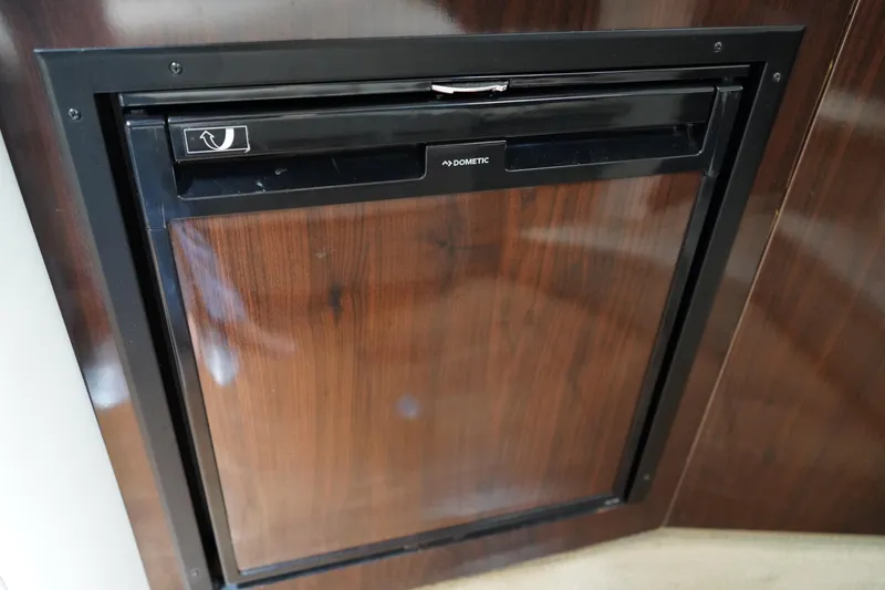 Slide: The Image of Built-in refrigerator on 2016 Sea Ray 330 Sundancer yacht, featuring a sleek wooden finish. - 44
