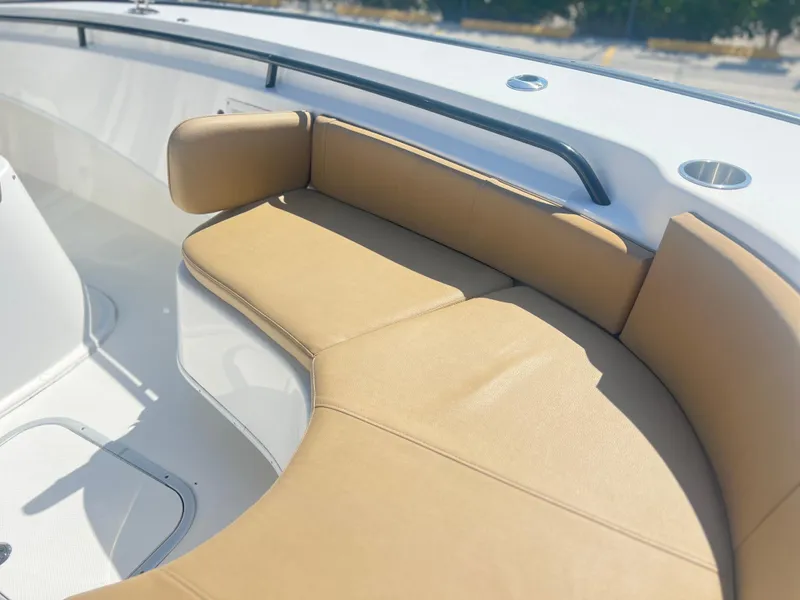 Slide: The Image of 2022 Cape Horn 24 XS boat with tan cushioned seating in the bow area. - 18