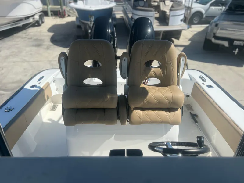 Slide: The Image of 2022 Cape Horn 24 XS boat interior with dual tan seats and steering wheel. - 29