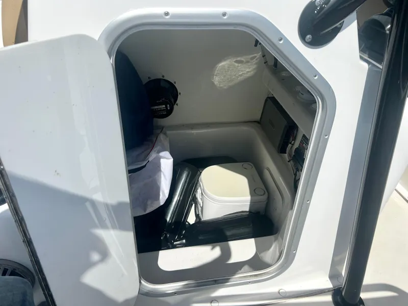 Slide: The Image of 2022 Cape Horn 24 XS boat interior with storage compartment and portable toilet. - 26