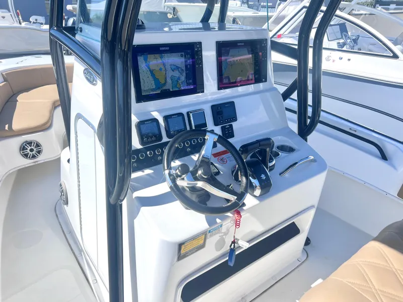 Slide: The Image of 2022 Cape Horn 24 XS boat dashboard with dual navigation screens and steering wheel. - 32