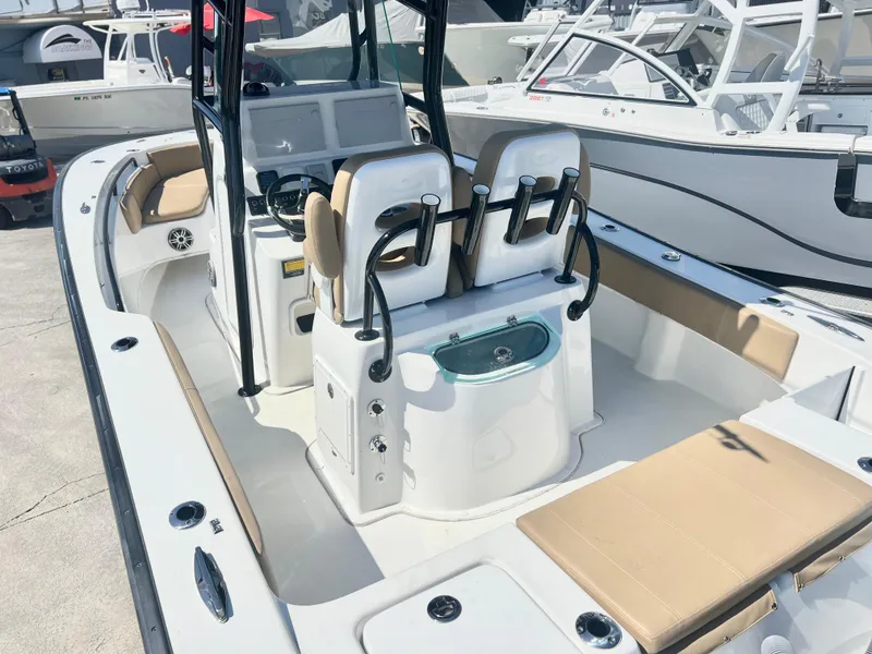 Slide: The Image of 2022 Cape Horn 24 XS boat interior with seating and control panel, docked in a marina. - 47