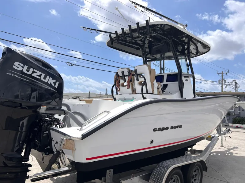 Slide: The Image of 2022 Cape Horn 24 XS boat with Suzuki engine on trailer, under a clear blue sky. - 8